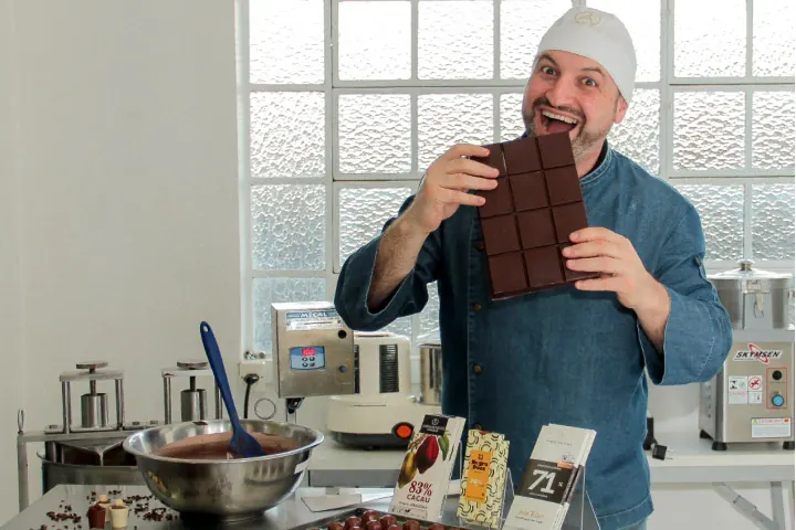 Andrei Martinez, chocolatier de Gramado, segurando uma barra de chocolate